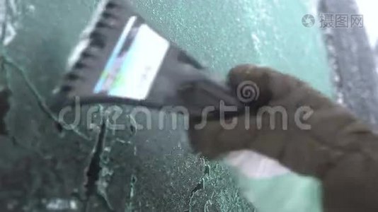 年轻女子在车上擦雪和冰。 冬季暴风雪视频