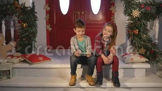 儿童在圣诞树附近玩手机、儿童和智能手机视频