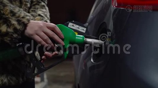 女人在冬天的加油站给她的车加油视频
