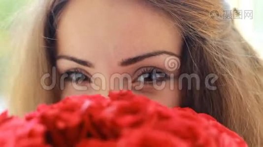美丽的女人用一束红玫瑰特写。视频