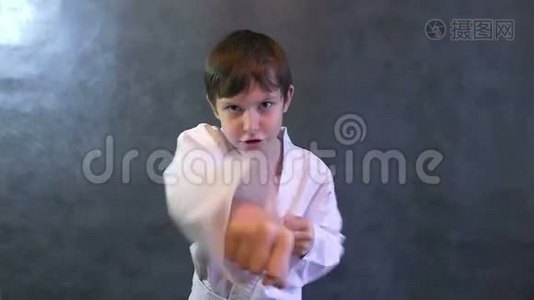 穿着和服的年轻空手道男孩挥舞着拳头慢动作视频