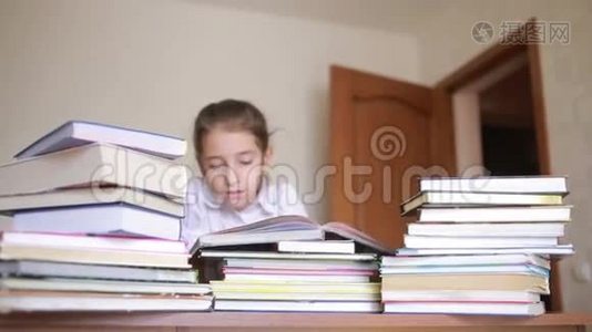 穿着校服的小女孩正在看书，坐在成堆的书之间视频