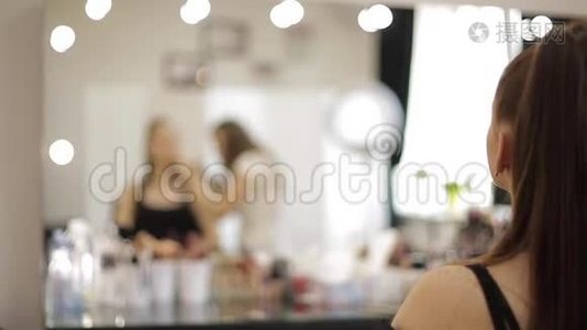 一位漂亮的女化妆师在一家大型美容院为一个红发少女化妆视频