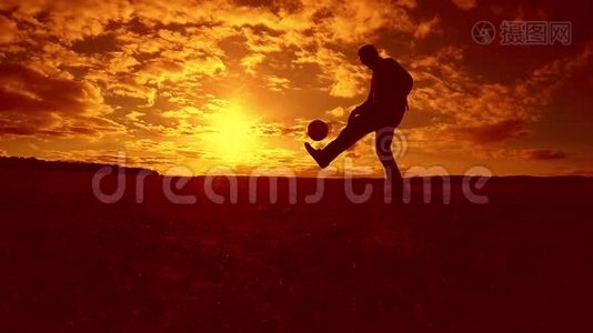 足球运动员填充球剪影人踢球生活方式在空中日落背景。 男人踢足球视频