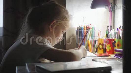 小女孩在灯光下在桌子上做作业。 小公主的创作爱好.. 生活方式视频