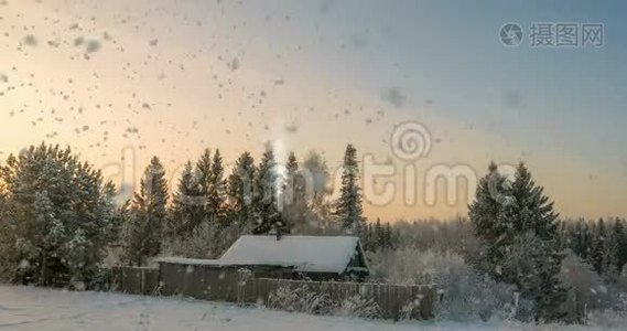 森林附近的一个小木屋，夕阳下一场美丽的降雪，一道美丽的冬季景观.. 视频循环视频