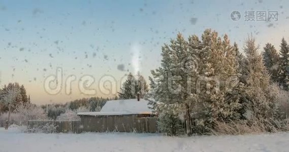 森林附近的一个小木屋，夕阳下一场美丽的降雪，一道美丽的冬季景观.. 视频循环视频