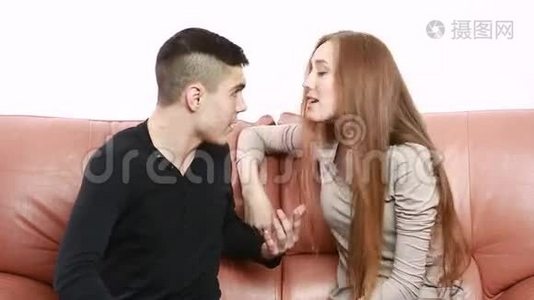 一对漂亮的年轻夫妇坐在沙发上争论不开心视频