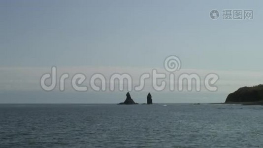 在日本海的海岸海滩上，绿色石岩上的海面波浪。视频