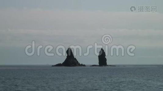 在日本海的海岸海滩上，绿色石岩上的海面波浪。视频