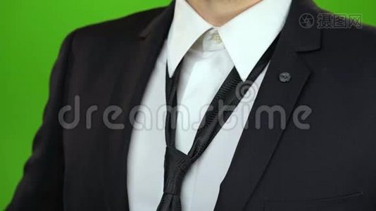 男人`手紧了脖子下面的领带。 绿色屏幕。 关门视频