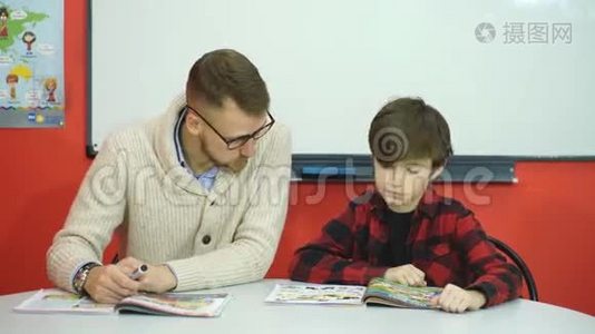 男生在教室里和老师一起学习视频