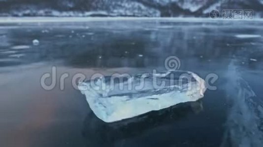 浮冰在令人惊叹的山景背景下在冰上旋转。 慢动作。 相机在移动视频