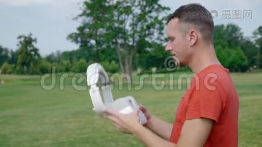 公园里一个男人把VR耳机戴在头上视频