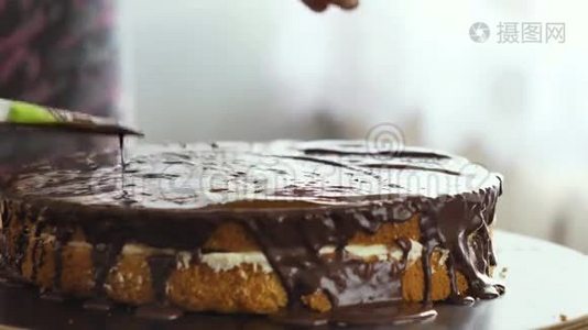女性手把巧克力奶油倒在蛋糕上，开始散开。视频