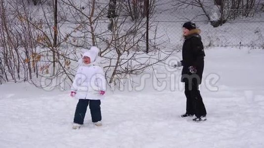 女孩和男孩玩雪球。 孩子们在冬季公园。视频