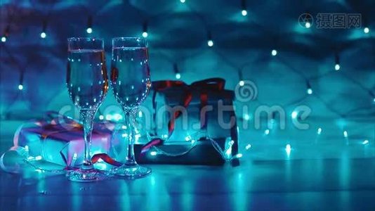 圣诞节和新年赠送两杯香槟蓝色花环背景视频