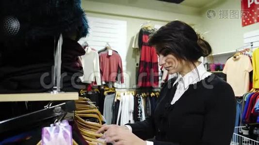 漂亮的女人在商店里挑选衣服视频