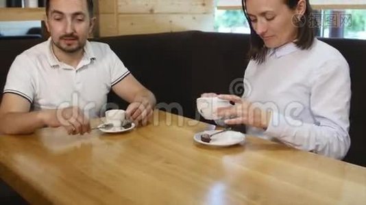 两个人在咖啡馆里喝着咖啡笑着视频