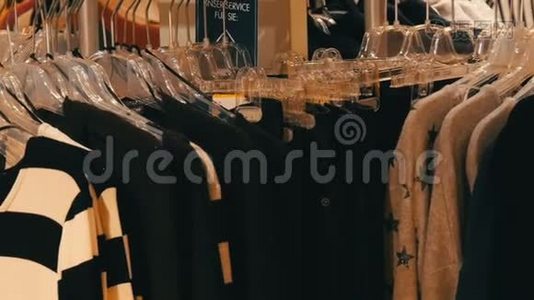 时尚的衣服挂在商场服装店的衣架上。视频
