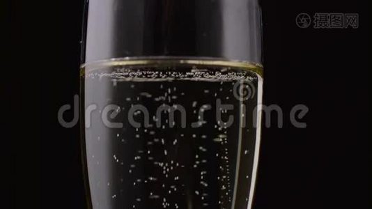 香槟倒入玻璃杯中。 黑色背景。 关门视频