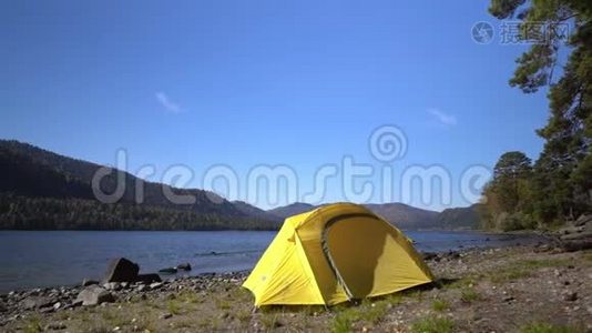 黄色帐篷在山湖畔花费..视频