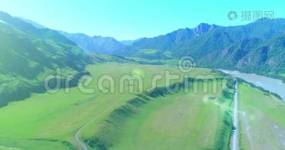 阳光明媚的夏季早晨，空中乡村山路和草地。 沥青公路和河流..视频