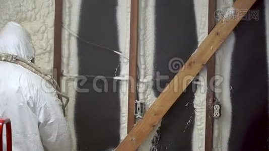 工人在家墙上喷涂封闭的电池喷涂泡沫绝缘材料视频