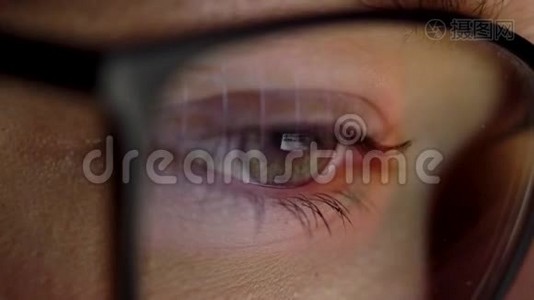 戴眼镜的女人看着显示器和上网。 监视器屏幕反映在眼镜上视频