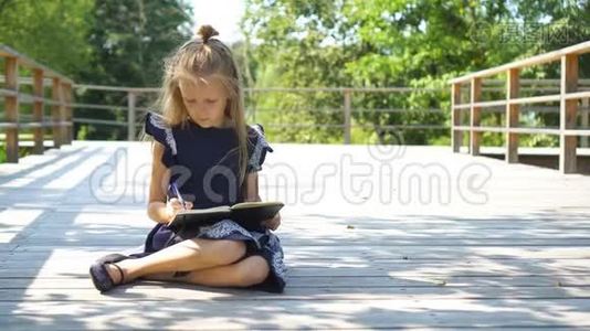 可爱的小女孩带着笔记和铅笔在户外。 回学校去。视频
