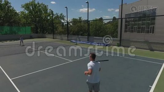 两个年轻人在球场打网球视频