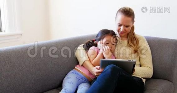 母女俩在客厅里用数码平板电脑视频
