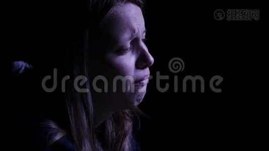 沮丧的少女在黑暗中哭泣。 4KUHD。视频