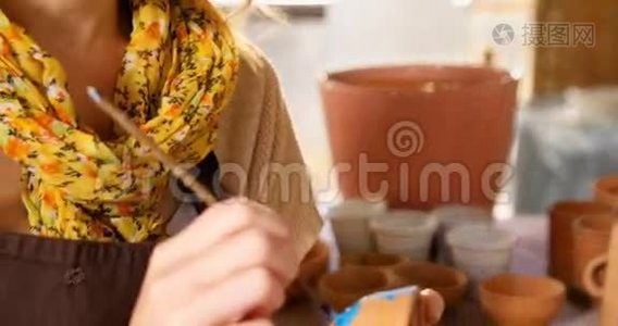 漂亮的女陶工在碗上画画视频