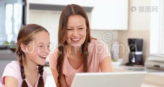 妈妈和女儿一起用笔记本电脑视频