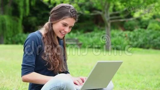 微笑的黑发女人用笔记本电脑视频