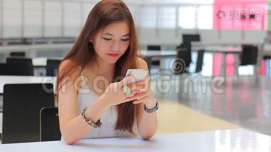 泰国成年漂亮女孩用她的智能手机和微笑。视频