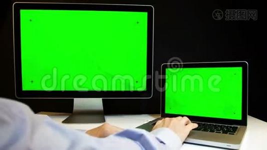 在笔记本电脑上工作并用绿色屏幕显示视频