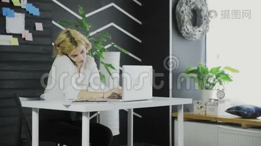 忙碌的商务女性在办公室用手机和电脑工作视频