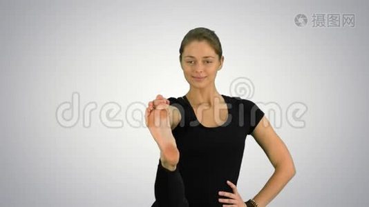 一个平衡和伸展的瑜伽姿势，女人在白色背景下练习视频