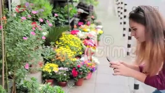 在欧洲街头的一家小花店里，一位年轻女子正在为鲜花拍照视频