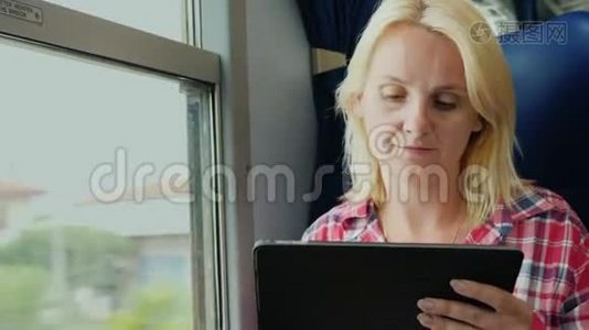 一直在线。 年轻女子在火车上享受平板电脑视频