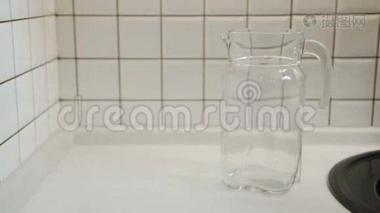 人在公寓的厨房里给水罐装满干净的水。视频