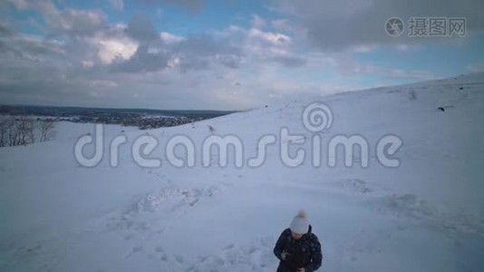 妇女和儿童一起在山上雕刻一个雪人。视频