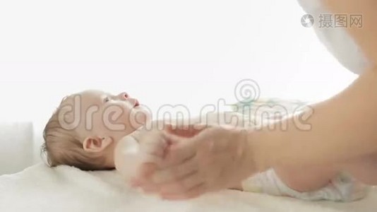 年轻母亲在大窗户前躺在床上聊天亲吻婴儿的特写镜头视频