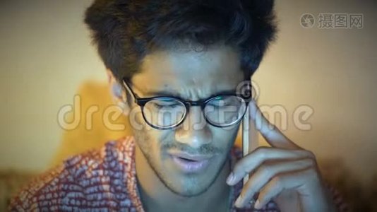 特写镜头，美丽的戴眼镜的印度男人在电话中交谈视频