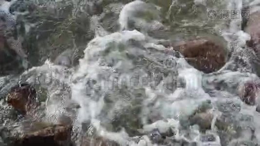 石头和白天海水的缓慢流动视频