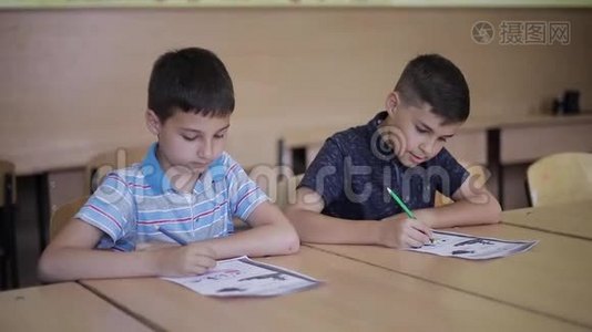 男孩和女孩坐在桌子上写着一篇文章视频