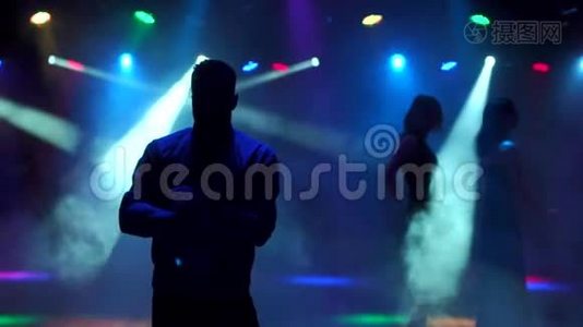 一个现代的年轻人在夜总会的黑暗中跳舞视频