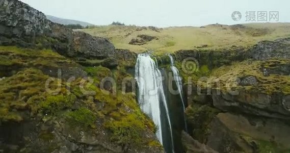 冰岛瀑布的鸟瞰图。 直升机飞过绿色的山谷和河流坠落。视频